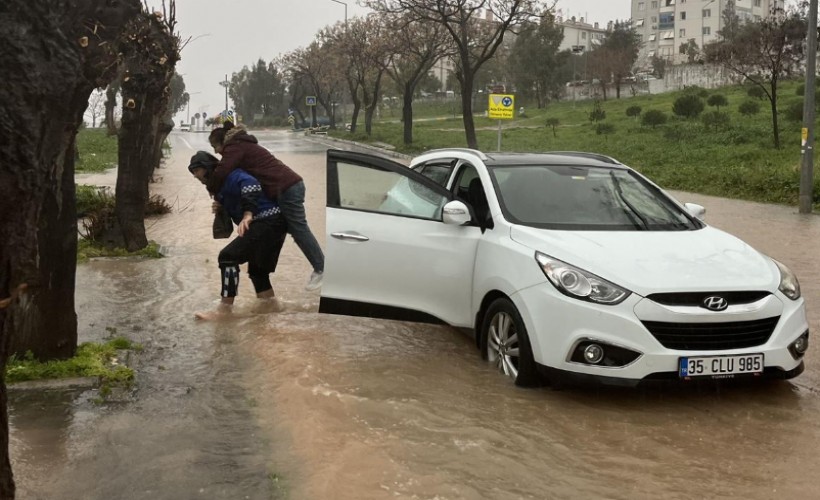 Büyükşehir’in zabıtası su basan yolda mahsur kalan İzmirliyi sırtında taşıdı