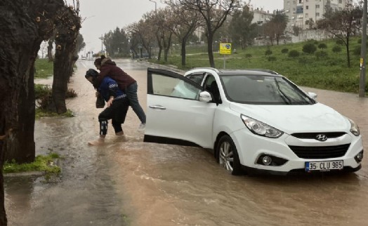 Büyükşehir’in zabıtası su basan yolda mahsur kalan İzmirliyi sırtında taşıdı