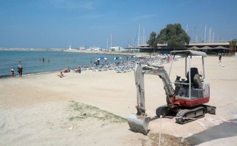 İş makinesi plajda güneşlenen turistlerin arasında çalıştı