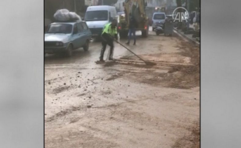 İzmir'de kürekle yolu temizleyen polisin görüntüsü sosyal medyada ilgi gördü